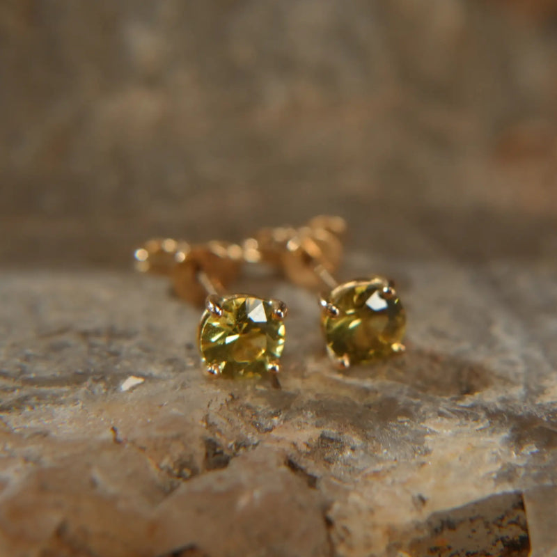 18K gold earrings with sparkling yellow sapphires on a stone surface, Eclat d'or jewelry