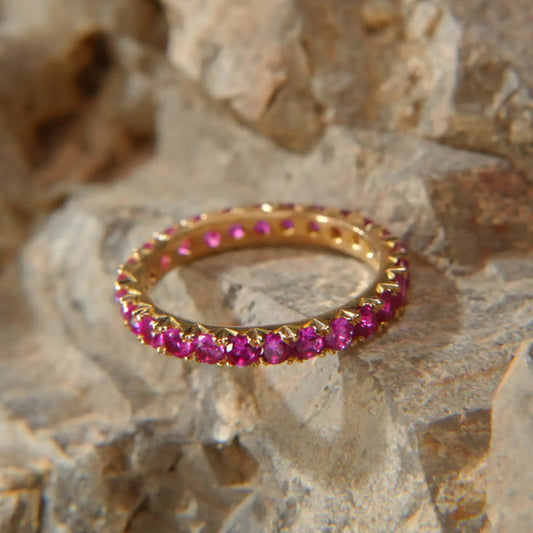 18K gold ring set with round pink gemstones, luxury jewelry by Eclat d'or on stone background