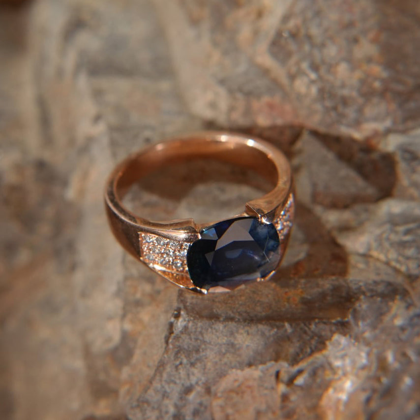 Gold ring with blue sapphire and diamond accents on stone background, Eclat d'or jewelry