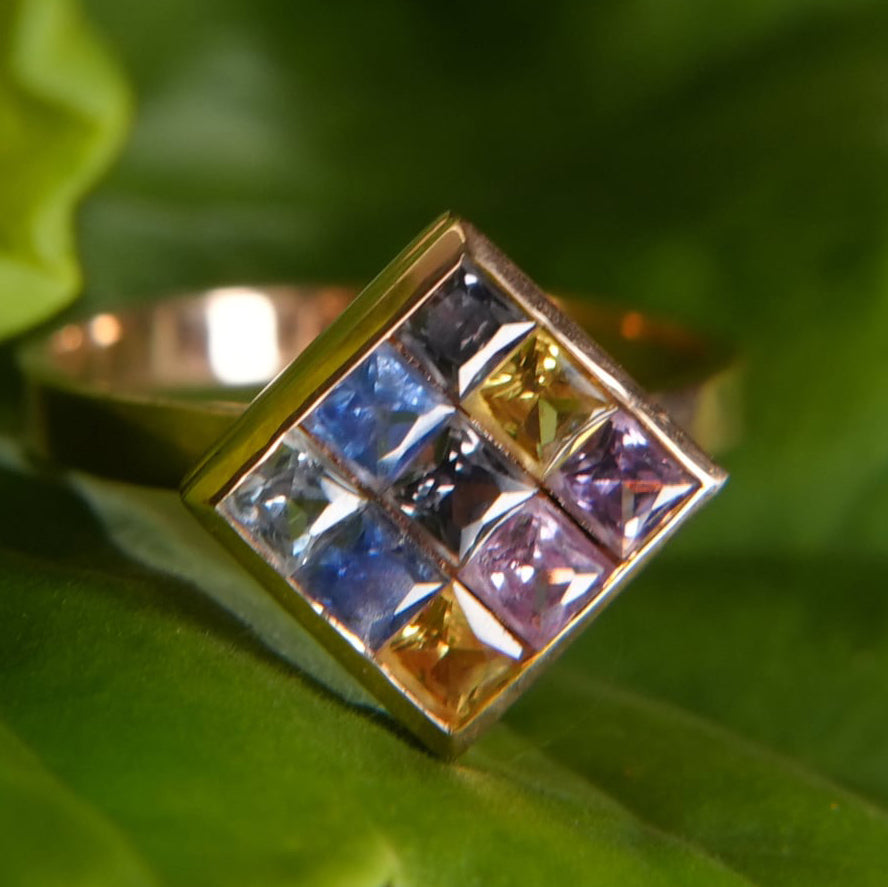 18K gold ring with multicolor sapphires, luxury jewelry from Eclat d'or, on green leaf
