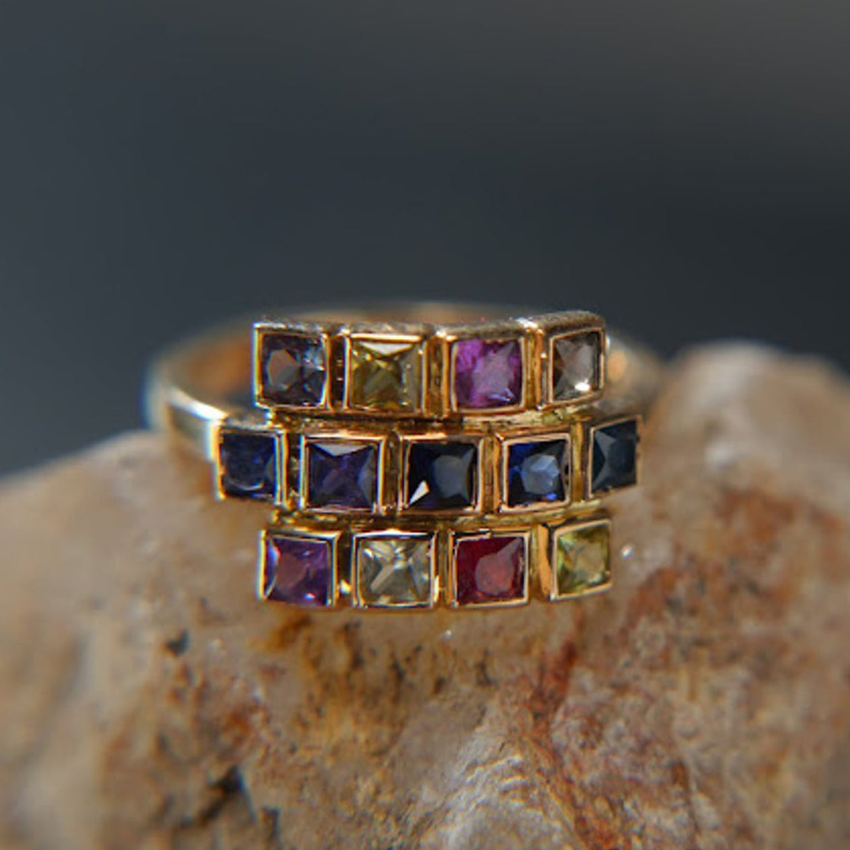 18k gold ring set with multicolored square sapphires, luxury jewelry on stone
