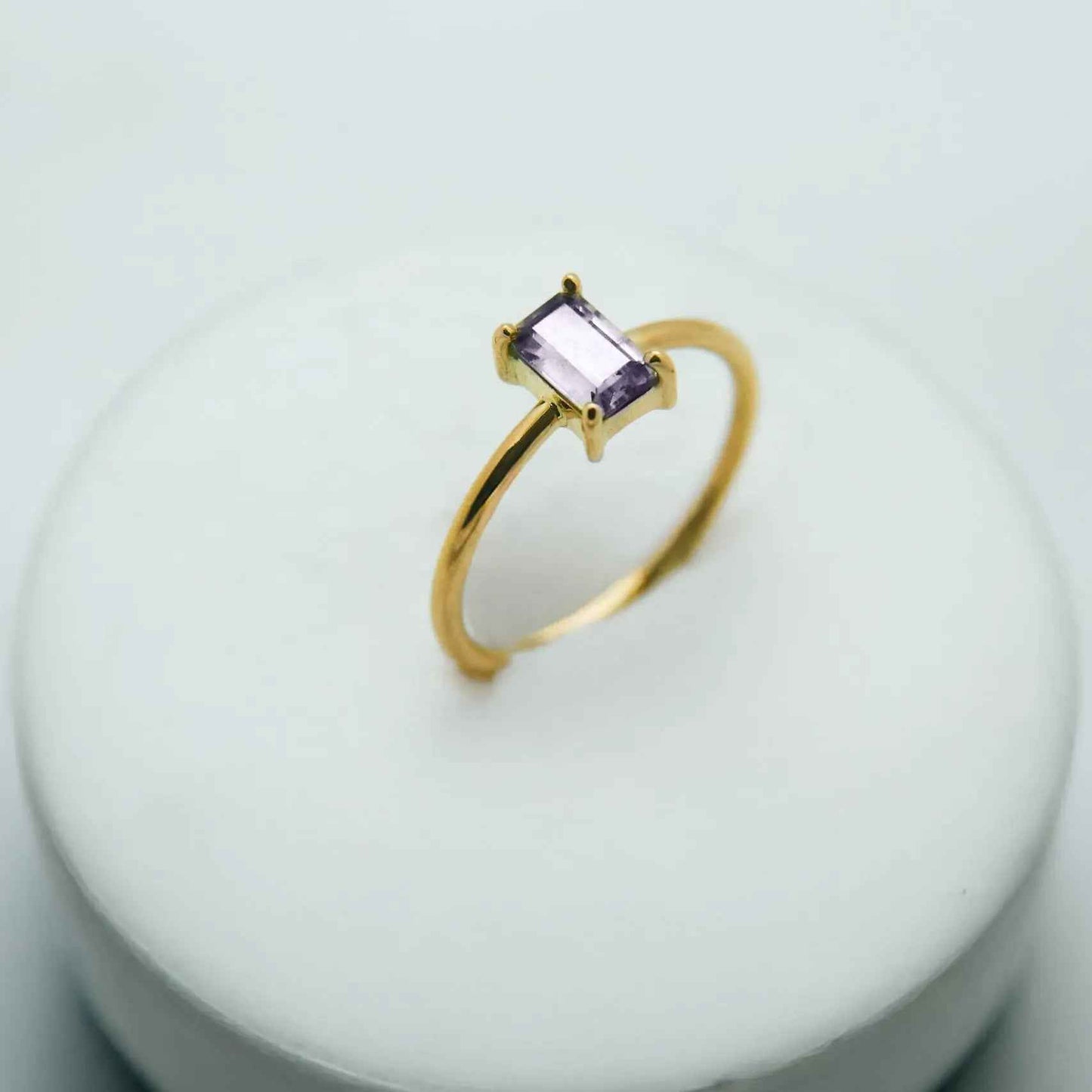 18k gold ring with rectangular color-change sapphire on white background, Eclat d'or jewelry