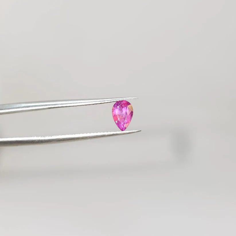 Pink pear-cut gemstone held by tweezers, precious stone for Eclat d'or fine jewelry