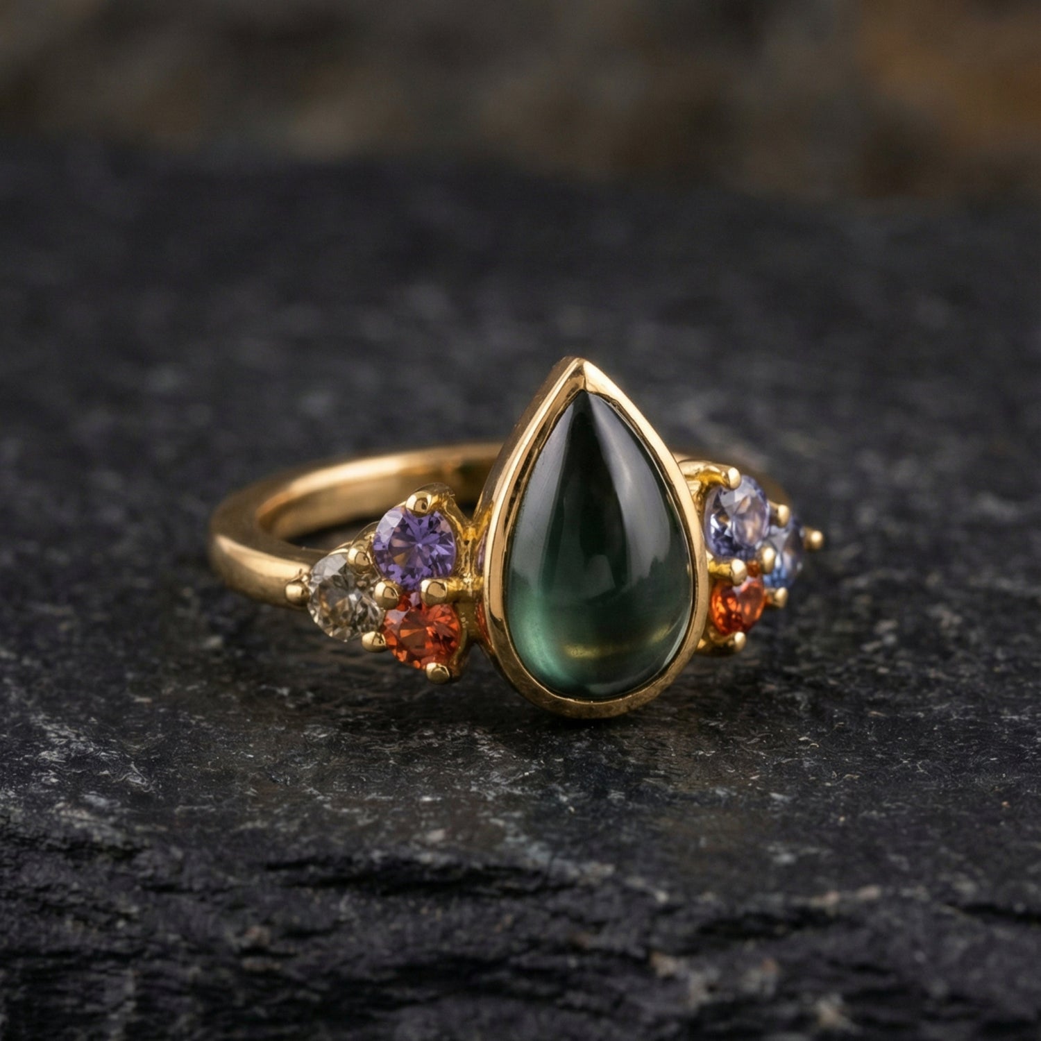 Gold ring with pear-shaped green stone and colorful gemstones, luxury Eclat d'or jewelry.